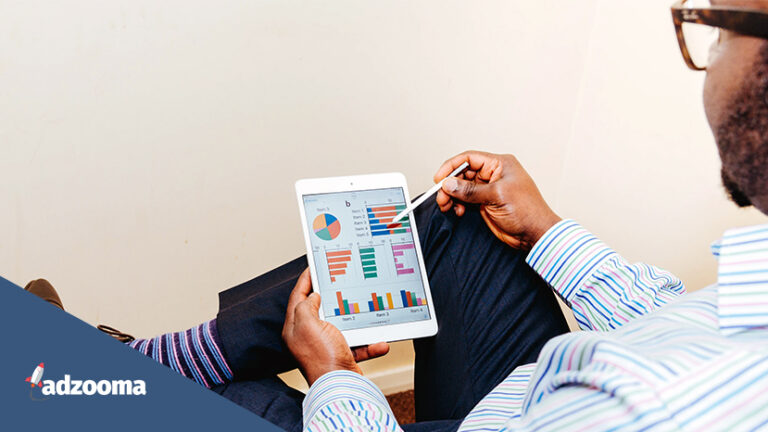 A Black man looking at graphs on a mini tablet